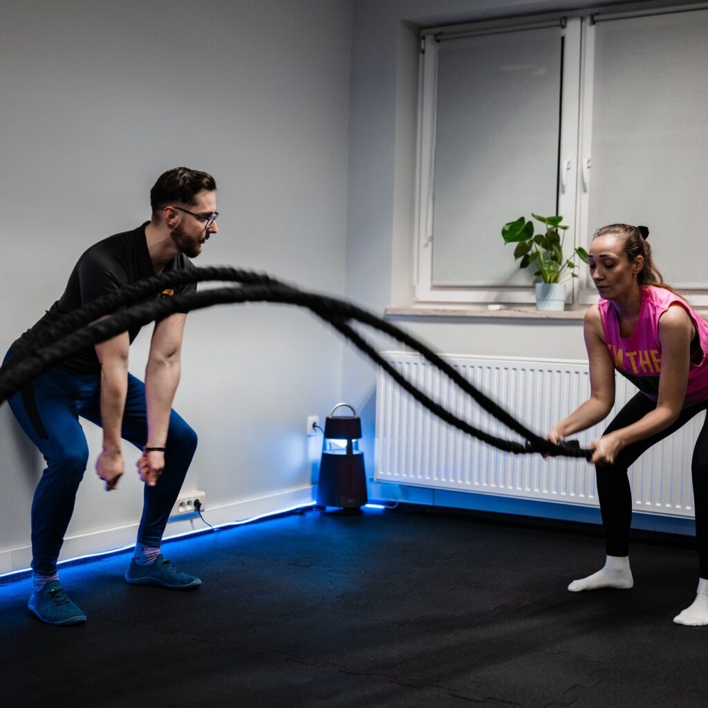 trening w Okularnik Trenuje Studio trener personalny z ćwiczącym na sali